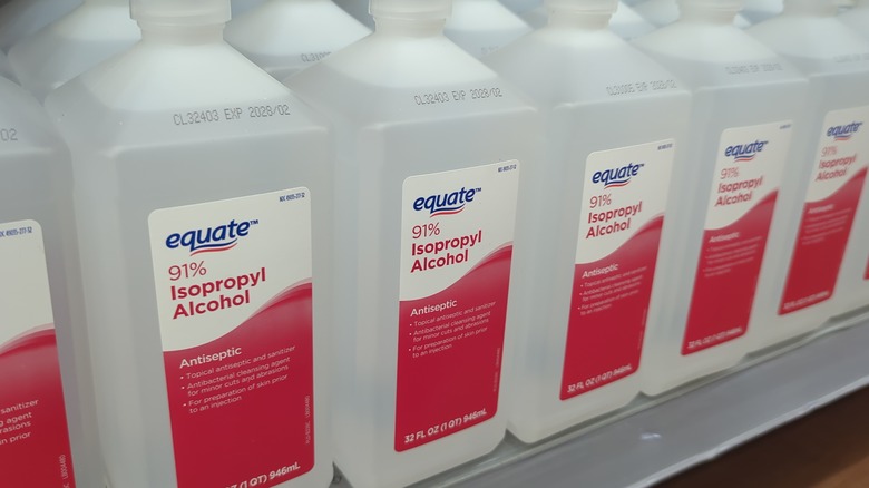 Bottles of rubbing alcohol on a shelf with red labels