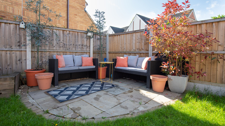 Outdoor patio area with seating and a rug