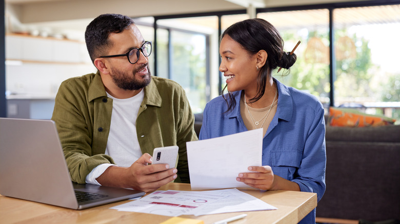 A couple looking at documents and phone screen