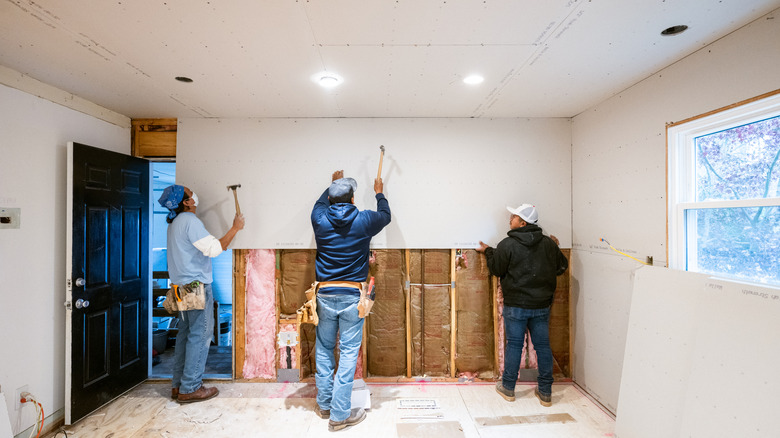 Workers installing drywall in a home