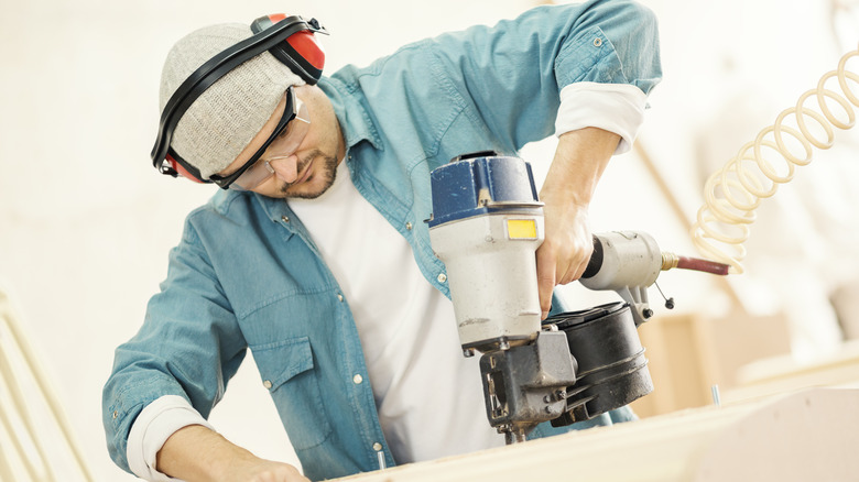 man using silver nail gun