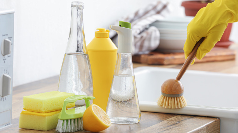 Spray bottle filled with white vinegar and other cleaning supplies