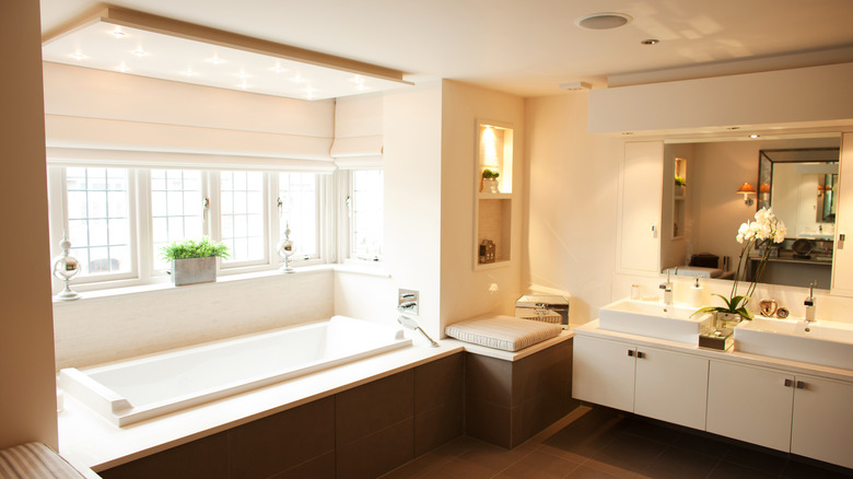 A spa style bathroom with low level bath, large vanity unit and neutral walls.