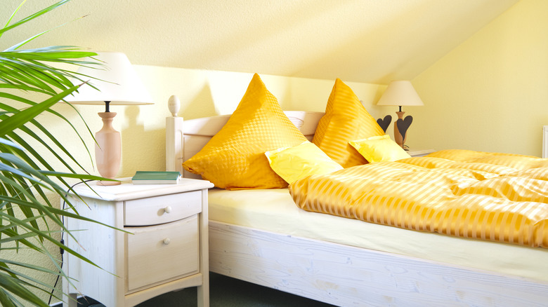 A warm and sunny eaves bedroom with yellow walls and bright yellow bedding.