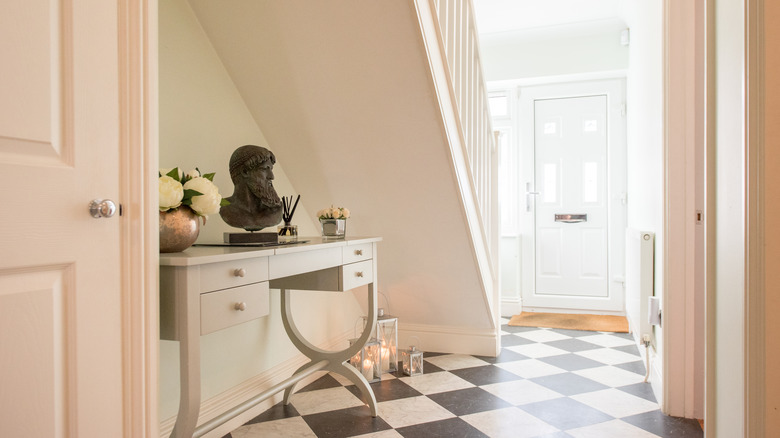 A bright hallway with understairs table and creamy beige walls.