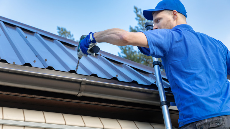 Worker installs metal roof.