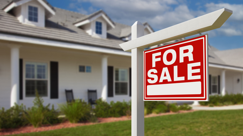 A for sale sign in a house's front yard