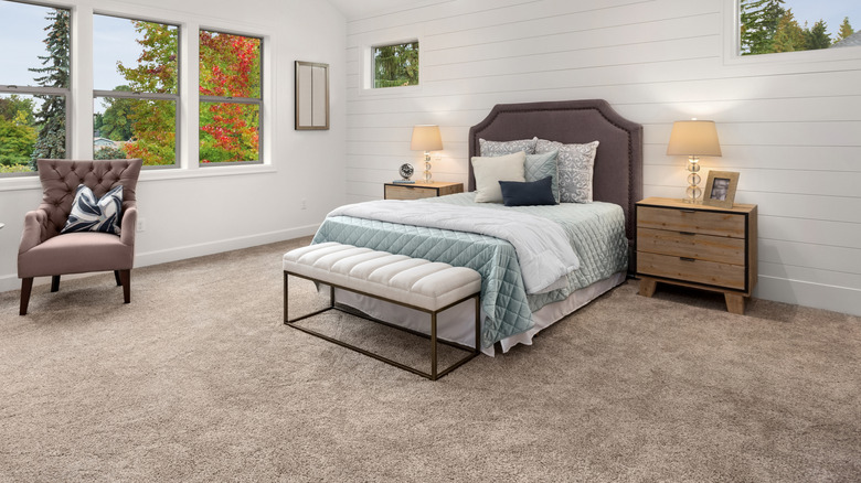 A bedroom with a thick beige carpet.