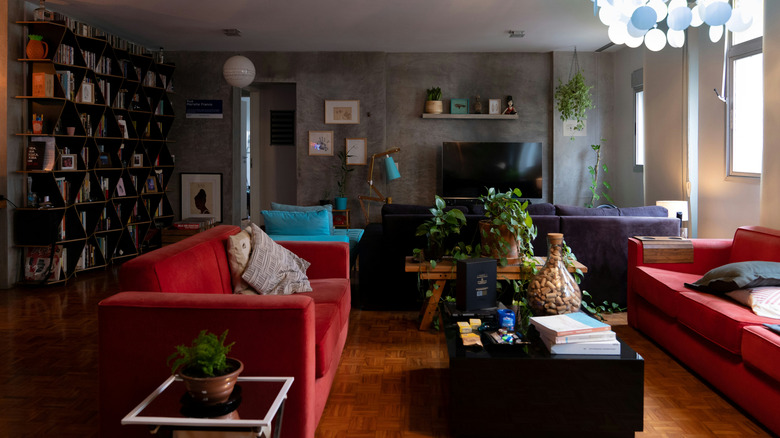 gray room with red sofas and bookshelves
