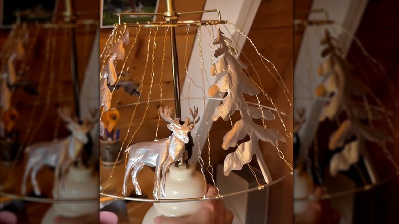 A DIY lampshade made with copper wire twists and woodland shapes cut from pop cans