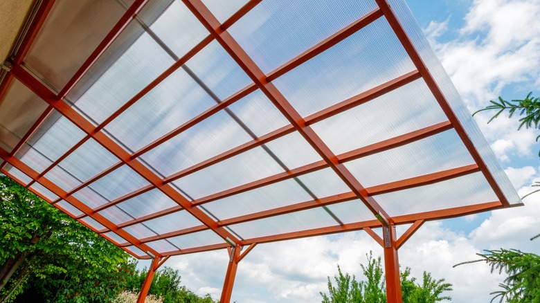 red aluminum pergola with transparent polycarbonate roof