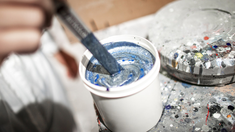 close up of mixing paint colors in a cup