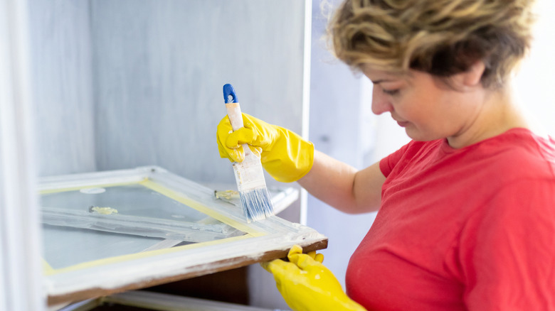 person painting window frames