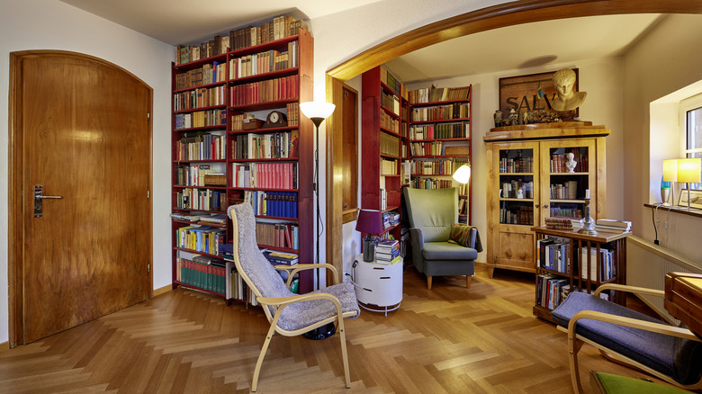 Home library with three separate bookshelves and a library cart.