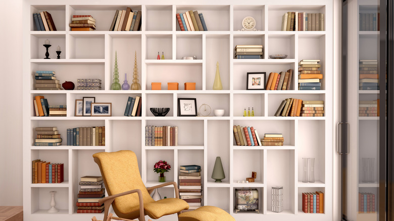 Large bookcase with cubby-style shelves used to display books, framed pictures, and decor.
