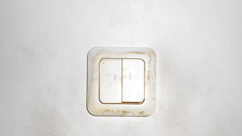 Dirty white switch board on a white wall