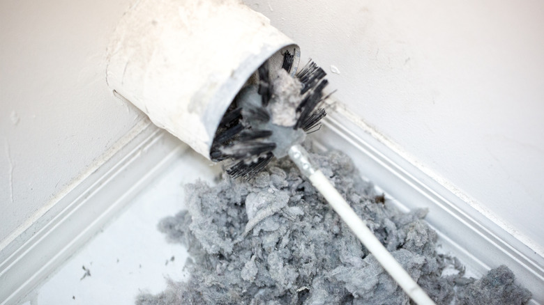 Brush inside of a very dirty dryer vent overflowing with lint