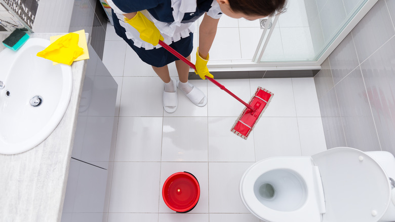 Woman cleaning bathroom floor