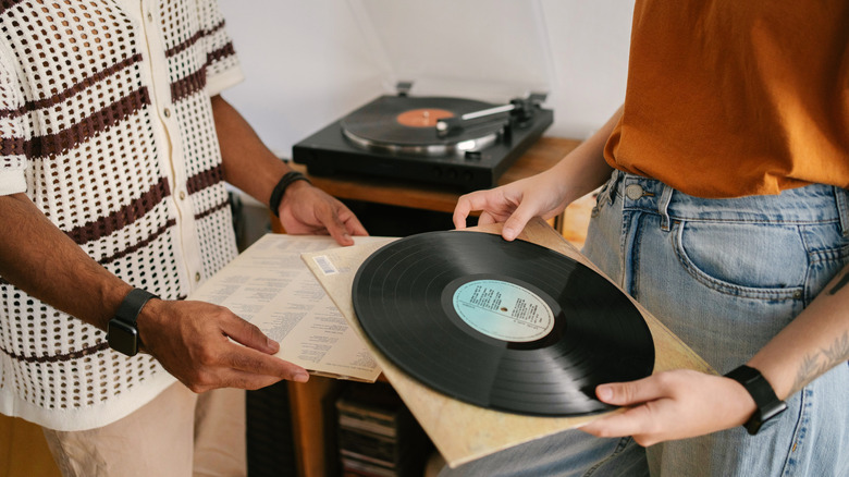 Man and a woman hold vinyl records