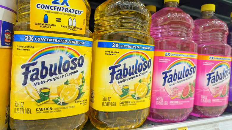 Bottles of Fabuloso cleaner in different colors line a grocery store shelf.