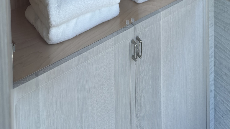 A set of bathroom towels are folded and organized in a linen closet.