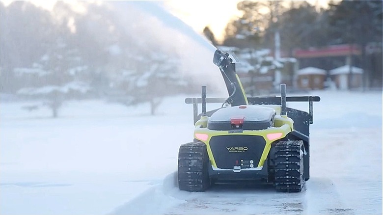 A Yarbo robotic snow blower removing snow from the ground.