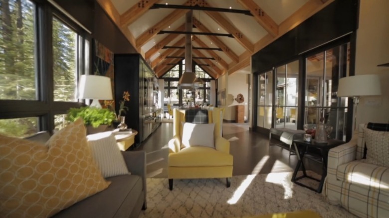A seating area with grey and white furniture and ceiling beams in the HGTV Dream House